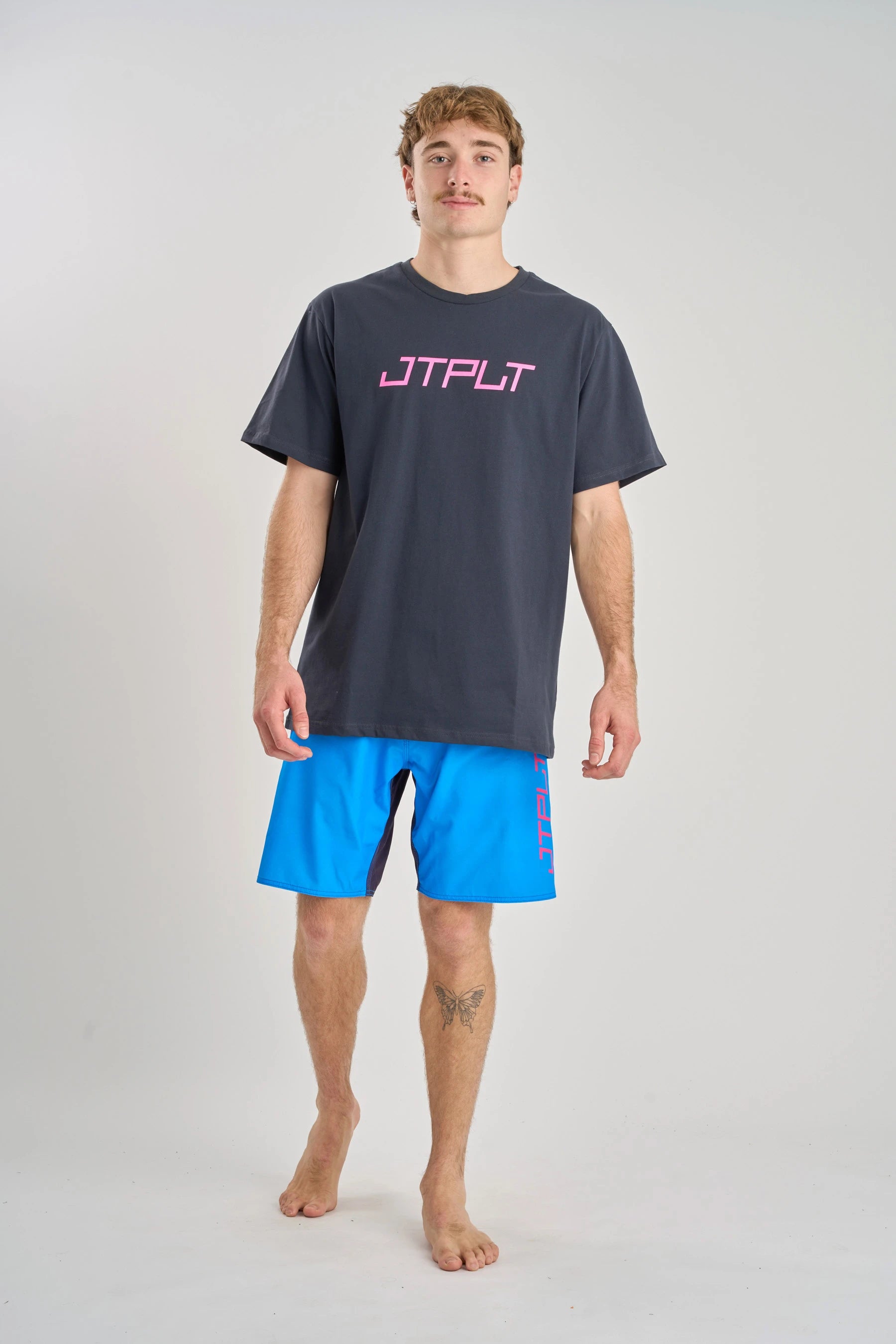 Man wearing a Jetpilot Vault SS Tee - Navy t-shirt with 'JTPLT' logo and blue shorts on a white background — image 2