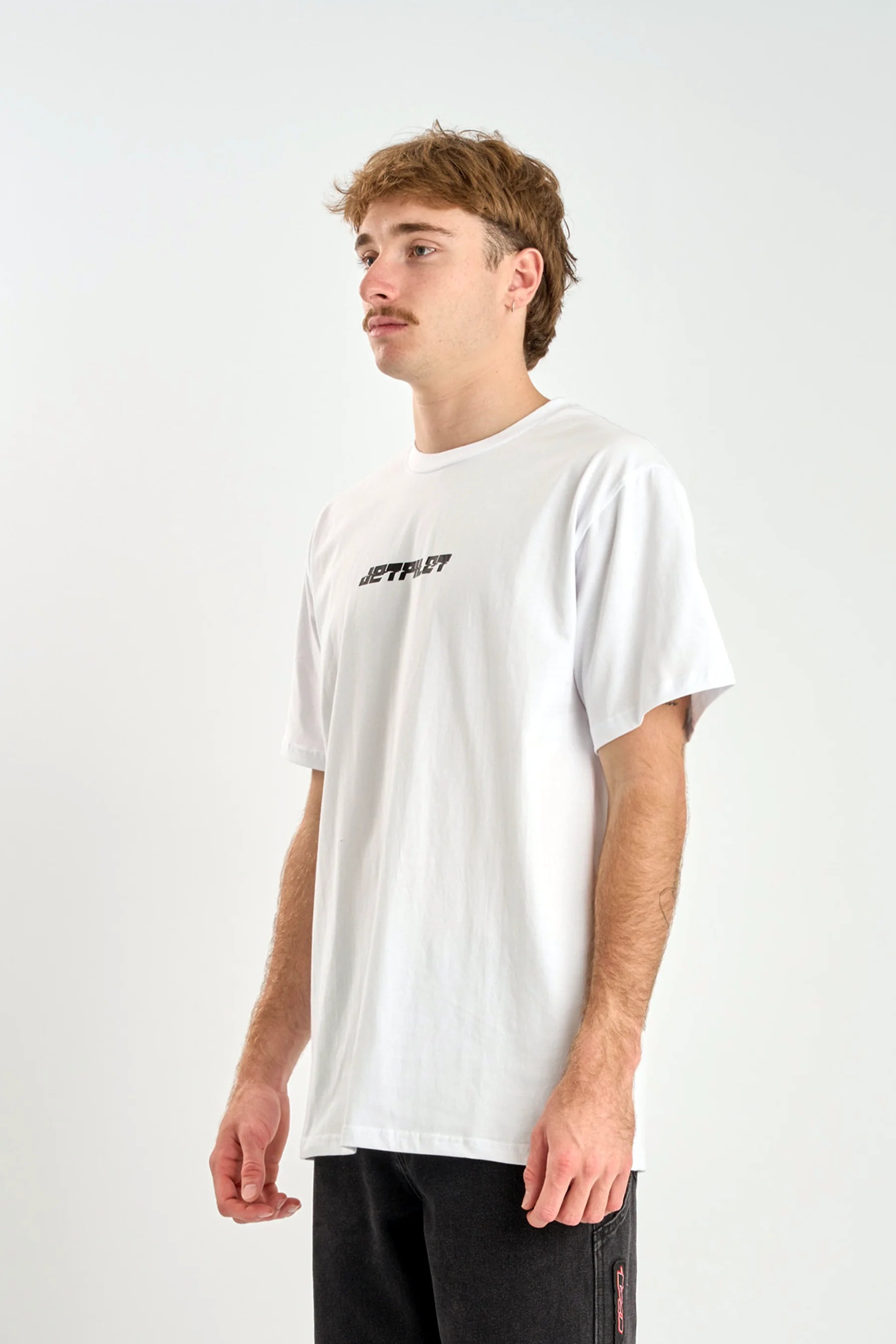 Person wearing a white t-shirt with text on a plain background — image 2
