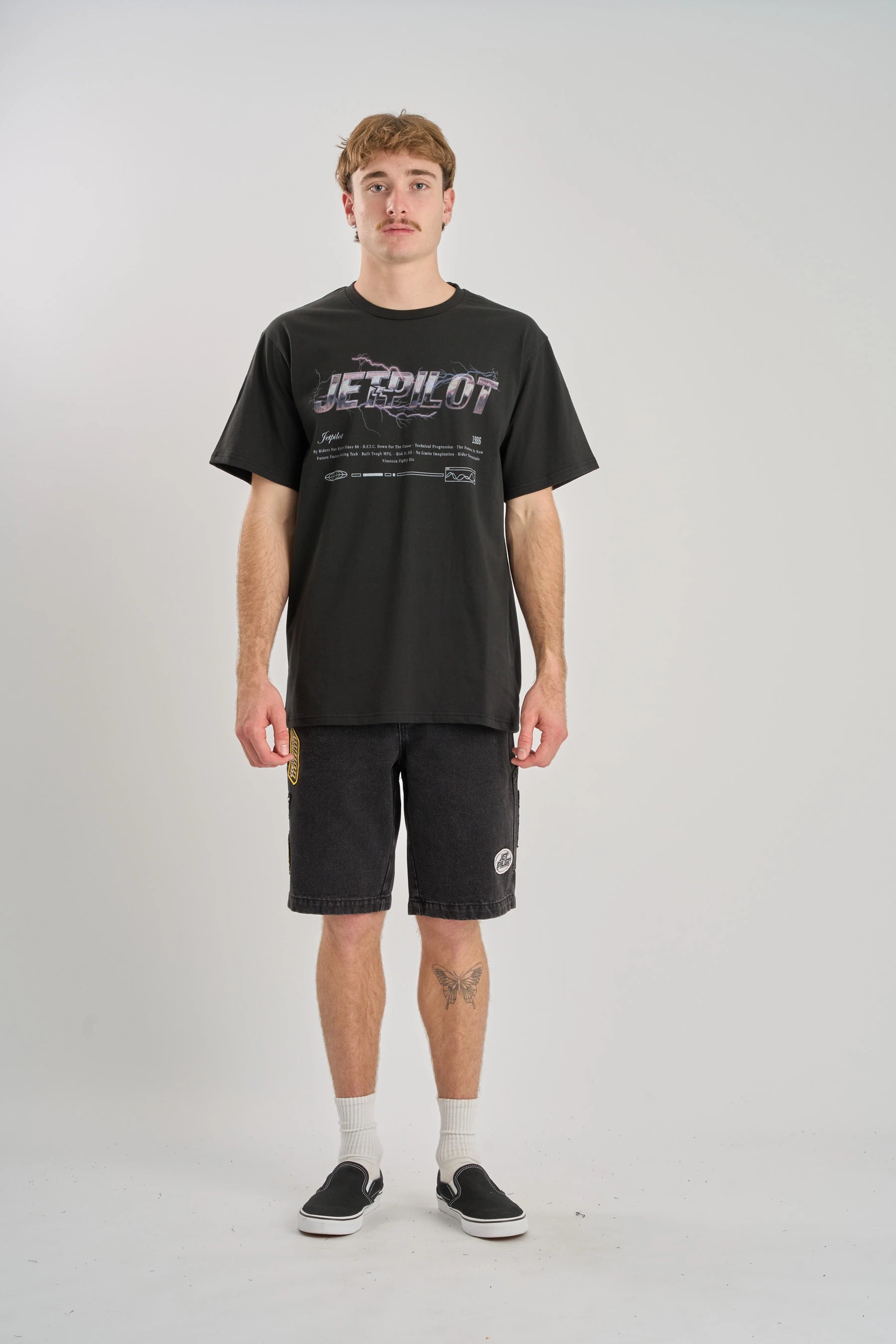 Person wearing a black t-shirt and shorts on a white background