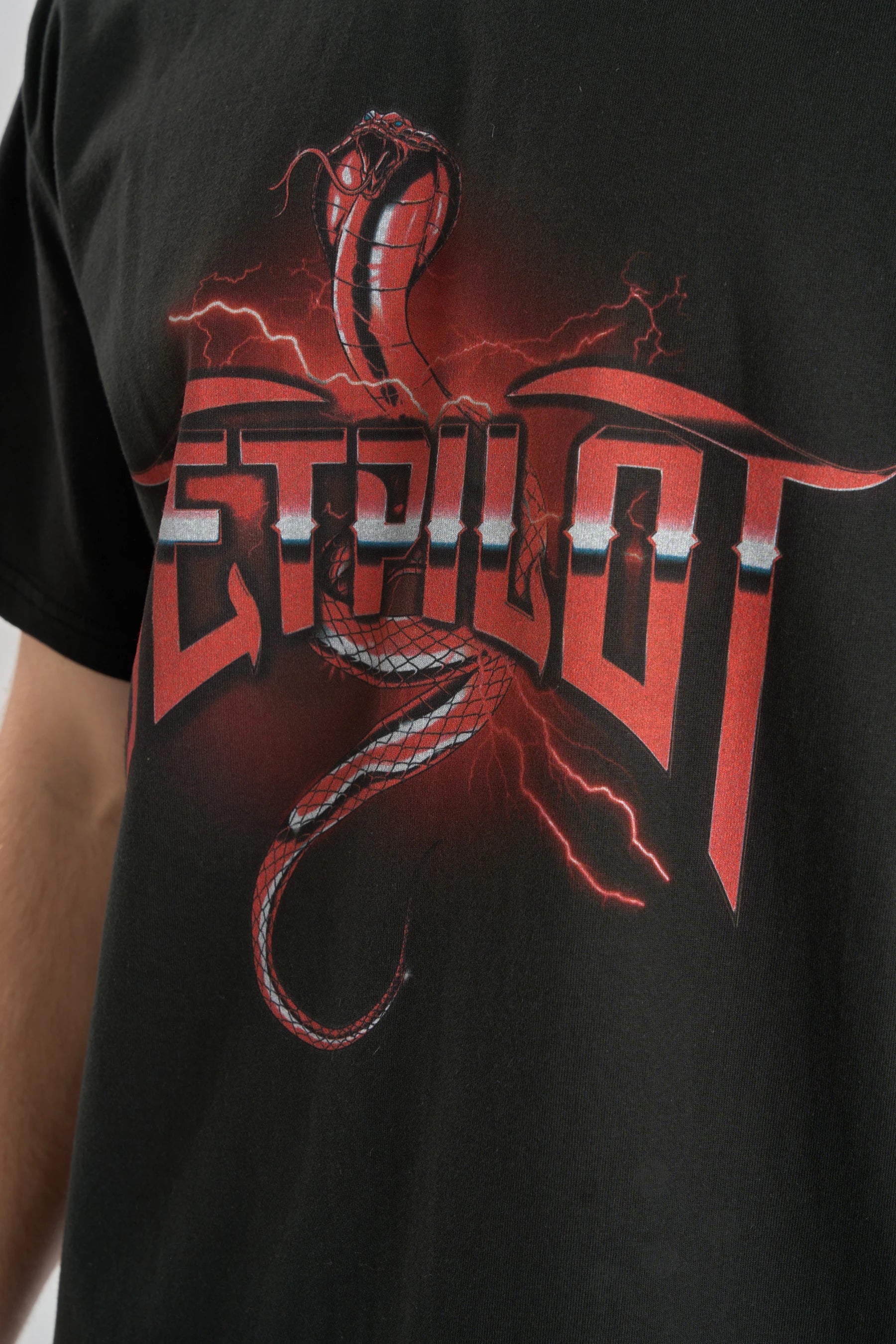 Black t-shirt with red and white graphic design featuring a snake and text on a plain background — image 2