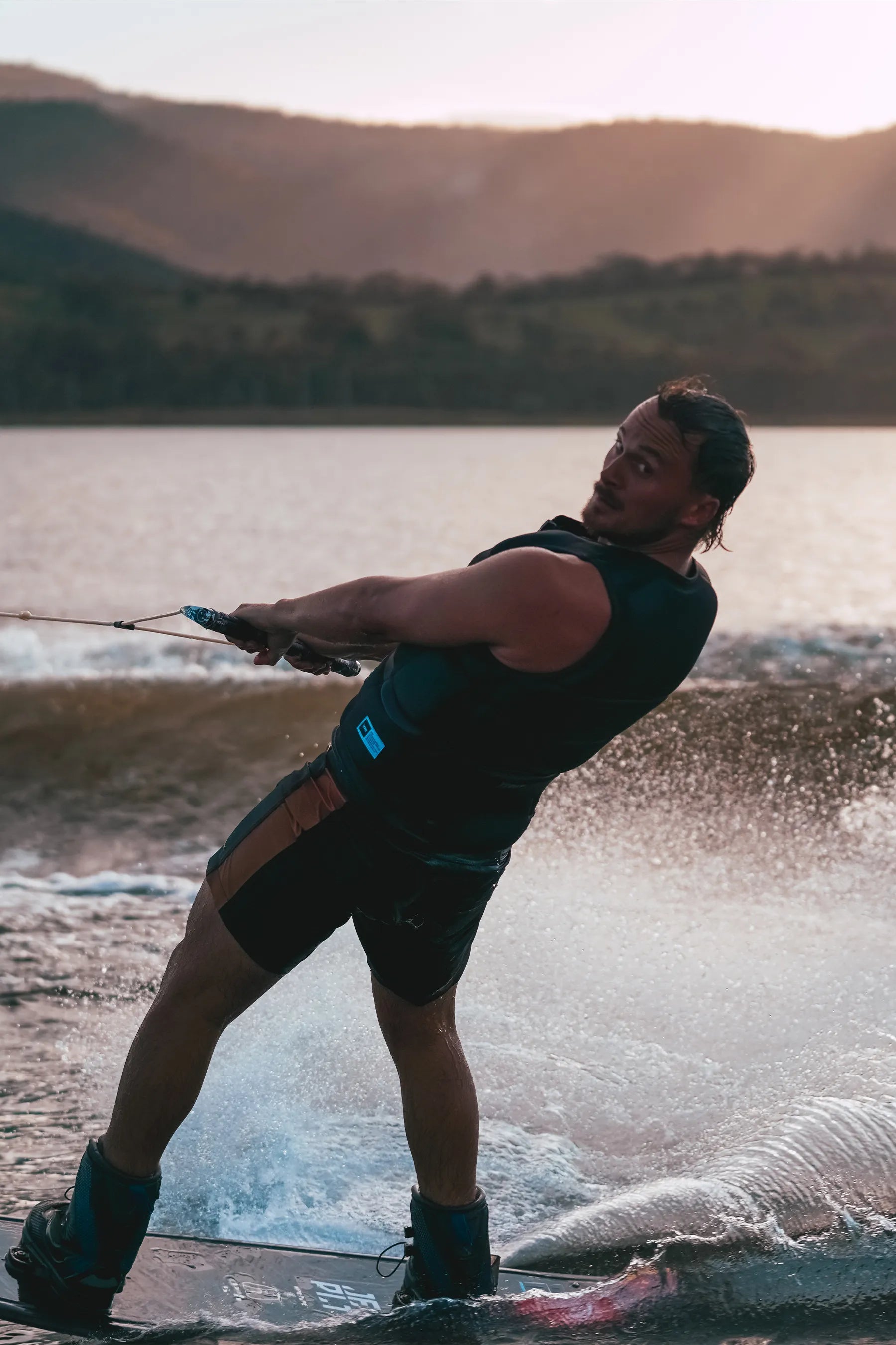 Person waterboarding on a lake with mountains in the background