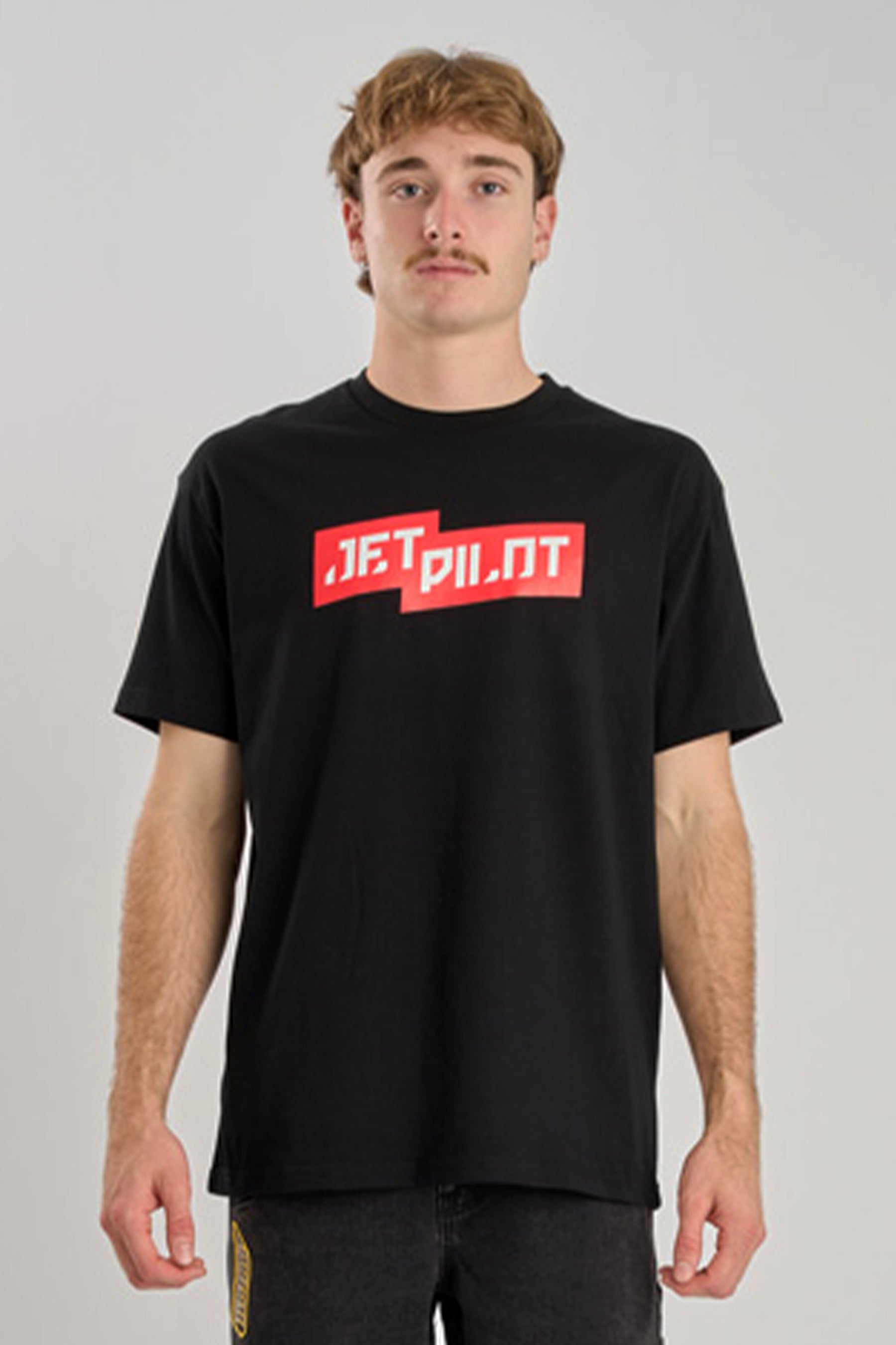 Person wearing a black t-shirt with red text on a gray background