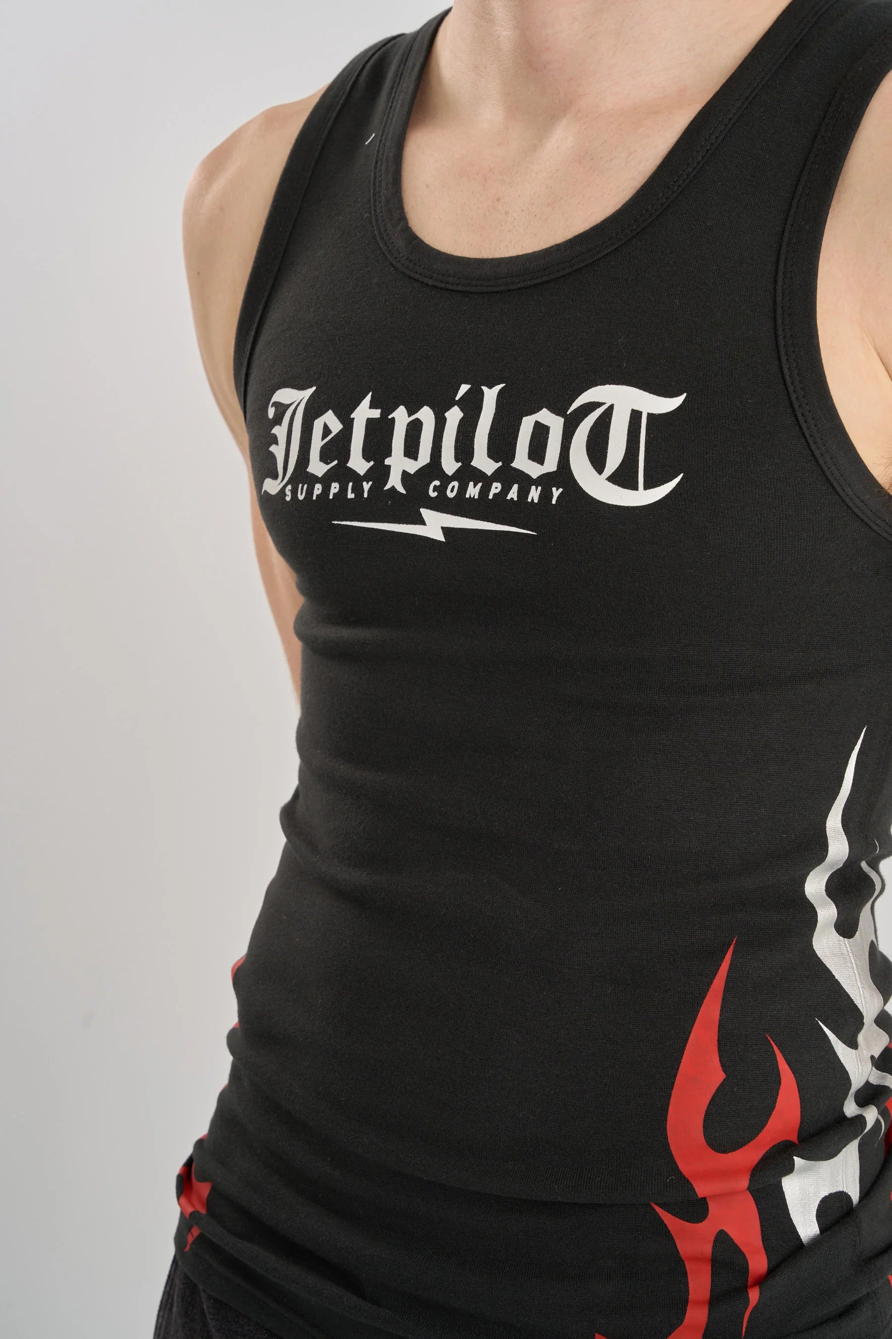 Jetpilot Tribal Singlet - Black with 'Jetpilot Supply Company' logo and flame design on a gray background