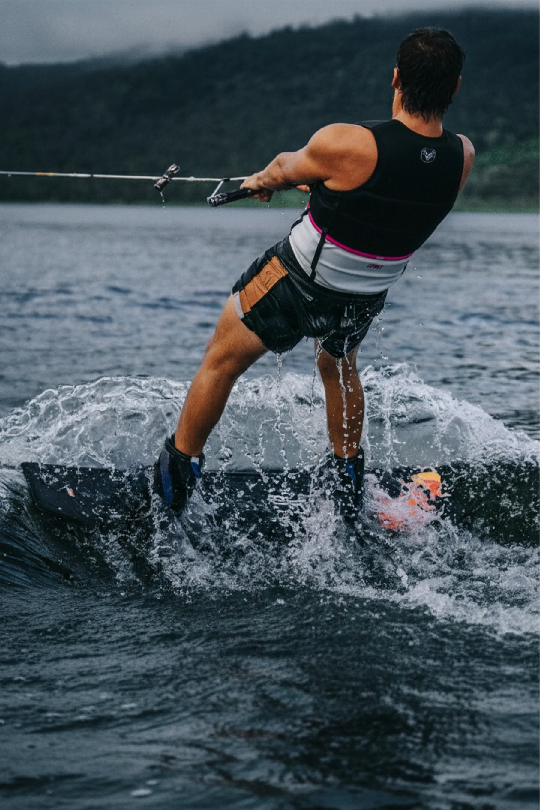 Person wakeboarding on a lake with mountains in the background