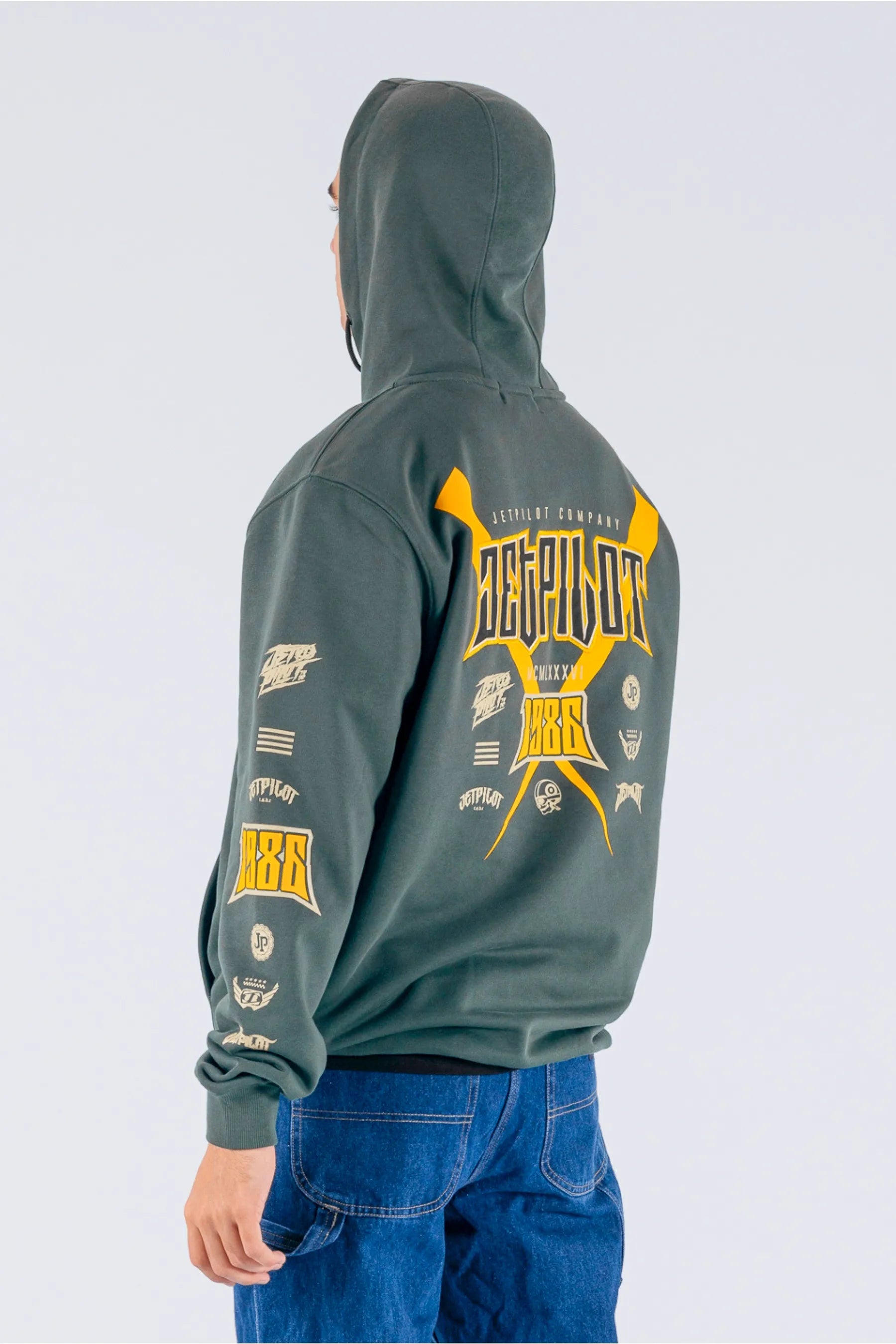 back/side view of a person wearing an amazon green pullover with a Jetpilot logos on a white background — view 2 (3)