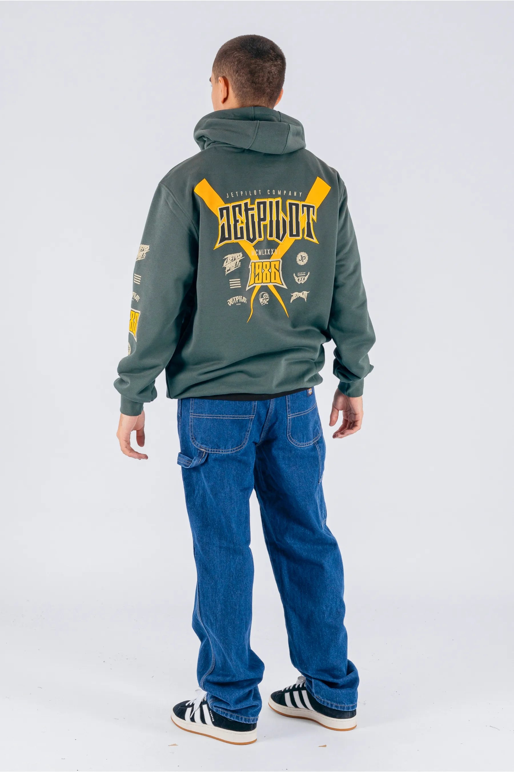 back view of a person wearing an amazon green pullover with a Jetpilot logos on a white background — view 4 (3)