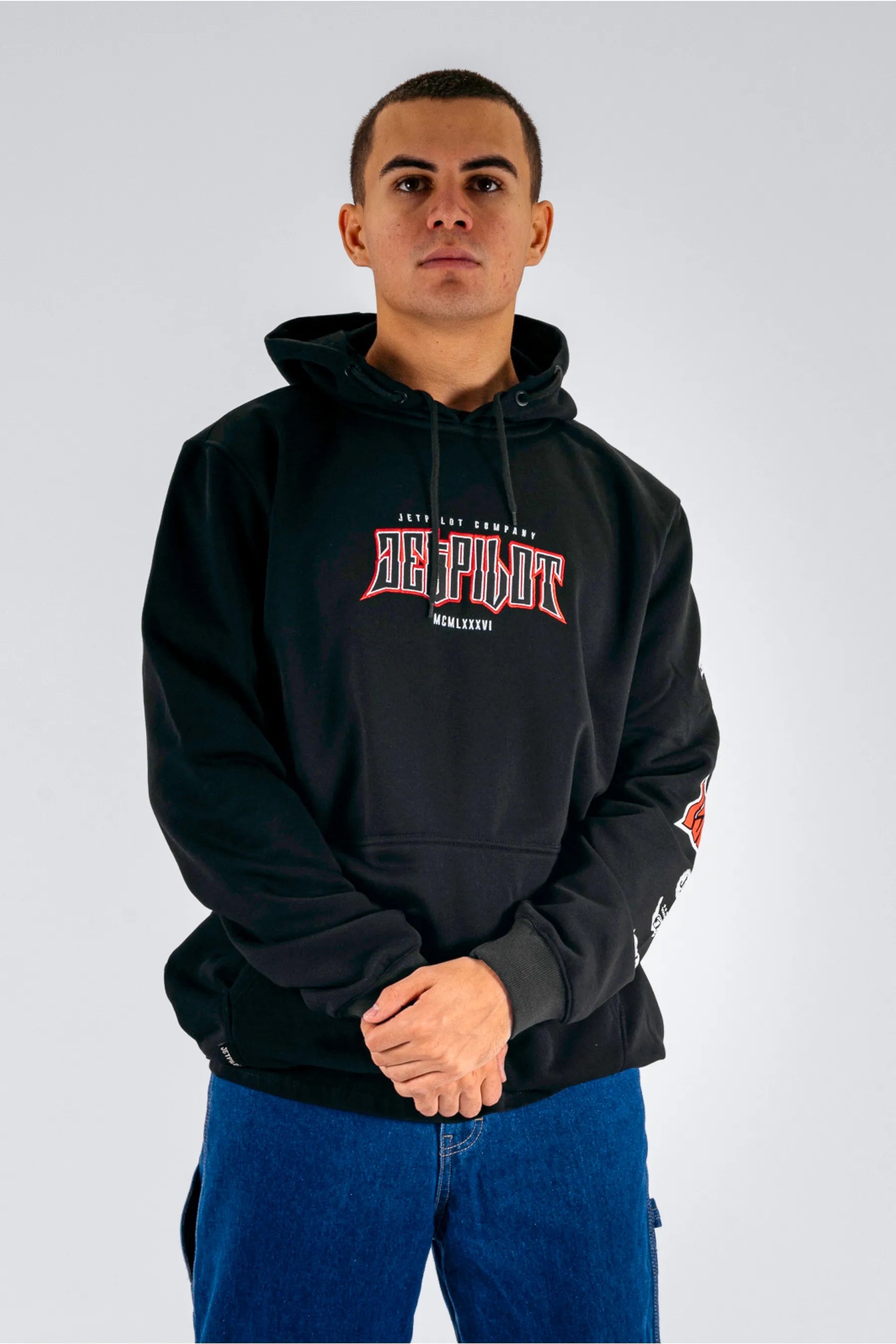 front view of a person wearing a black pullover with a Jetpilot logo on a white background — view 1 (5)