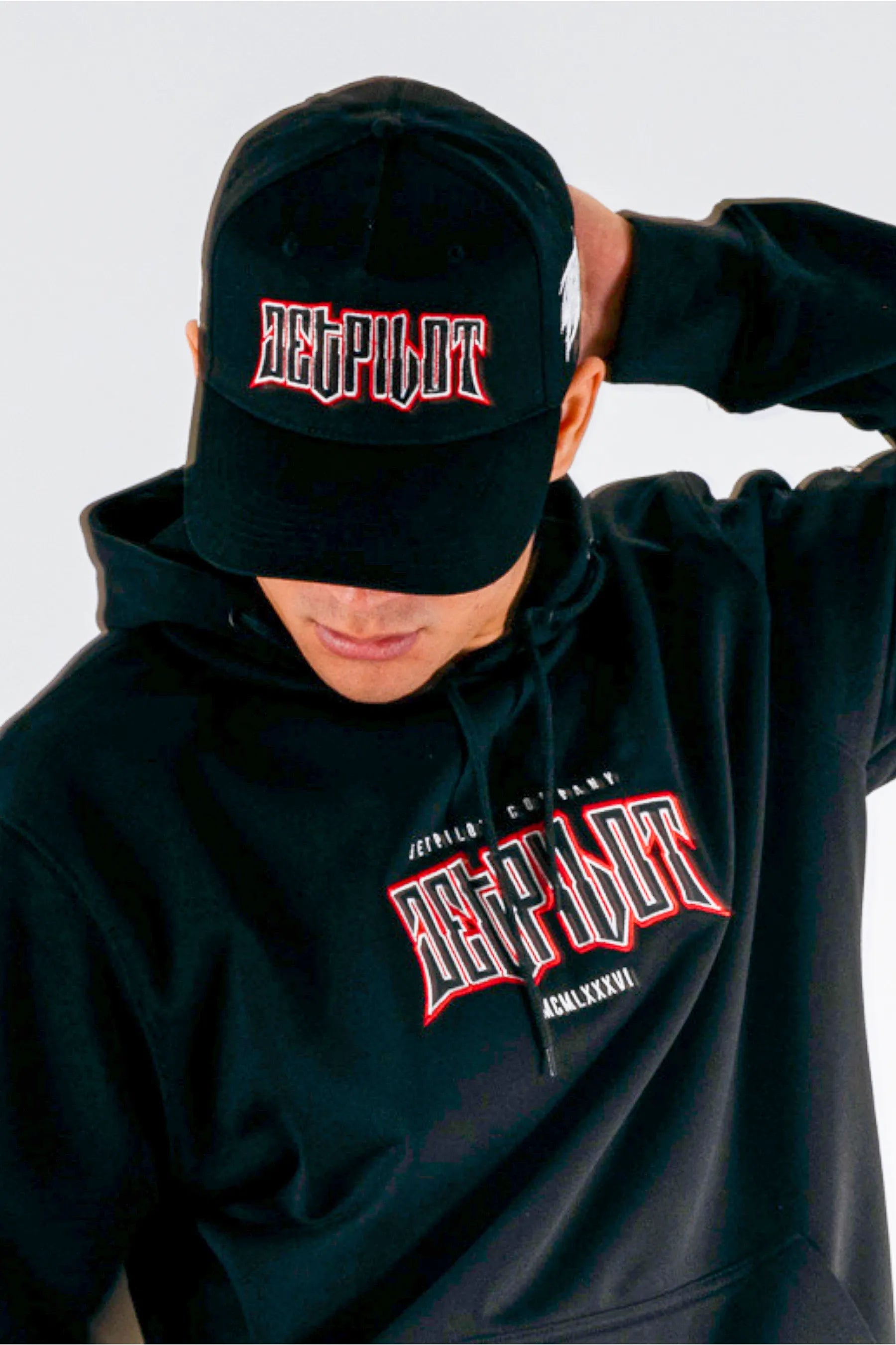 Front view of a person wearing a black snapback with a Jetpilot logo on a white background — view 4 (3)