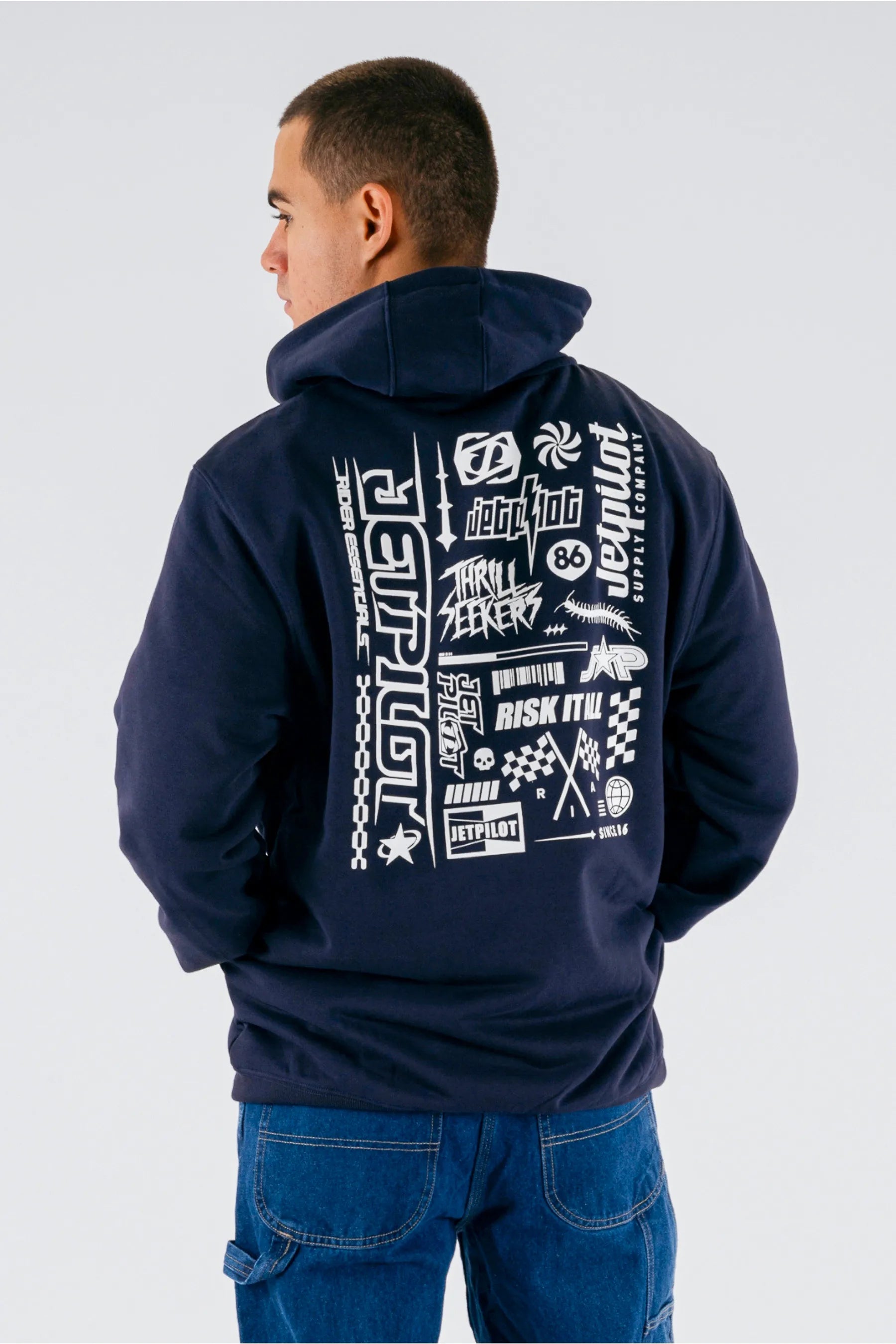 back view of a person wearing a dark blue pullover with a Jetpilot logos on a white background — view 2 (3)