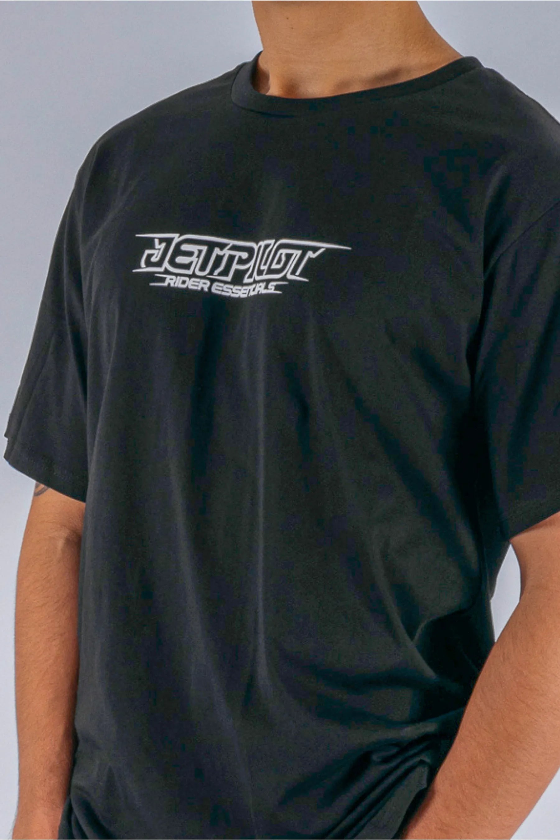close up of a person wearing a black tee with a Jetpilot logo on a white background — view 4 (5)