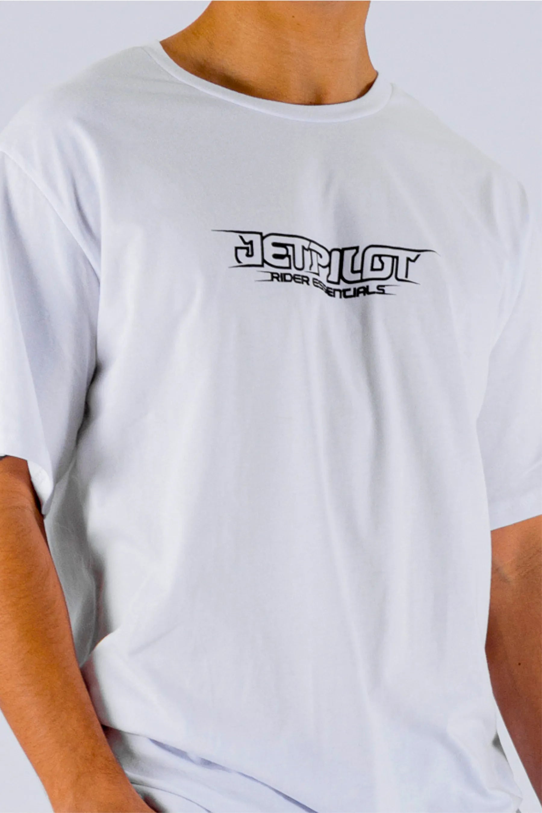 close up of a person wearing a white tee with a Jetpilot logo on a white background — view 4 (4)
