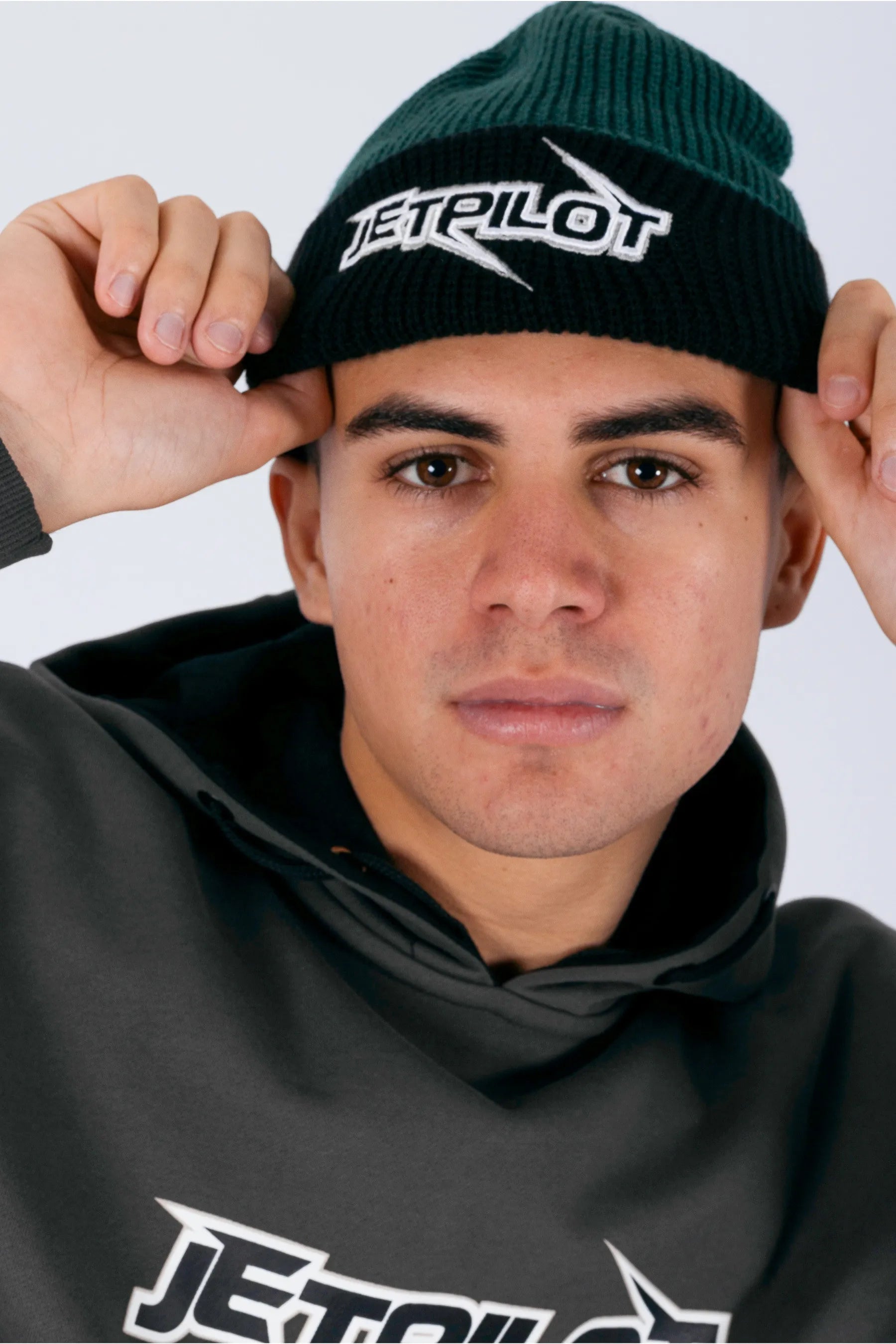 Front view of a person wearing a amazon green beanie with Jetpilot logo with a white background — view 1 (3)