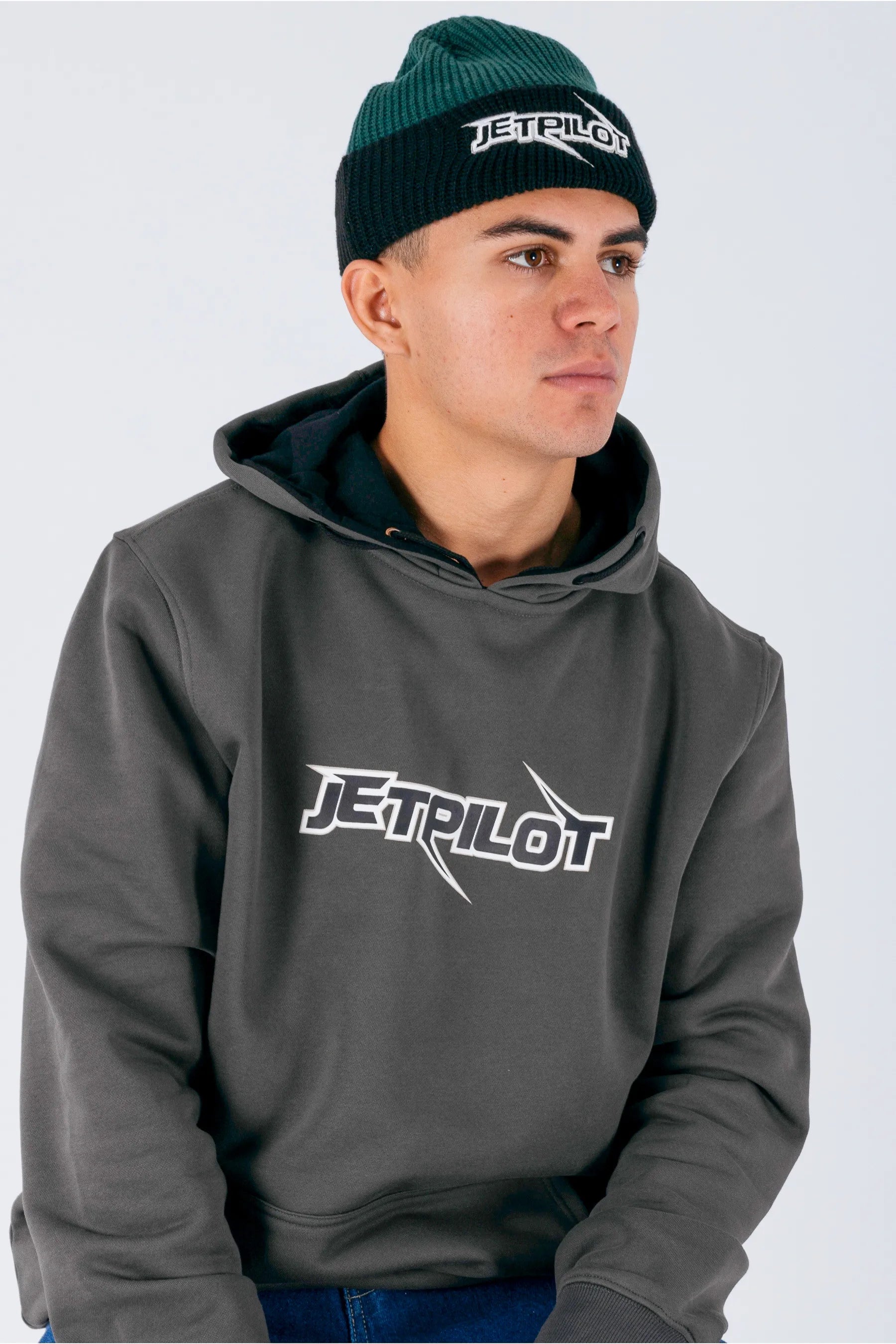 Side view of a person wearing a amazon green beanie with Jetpilot logo with a white background — view 2 (3)