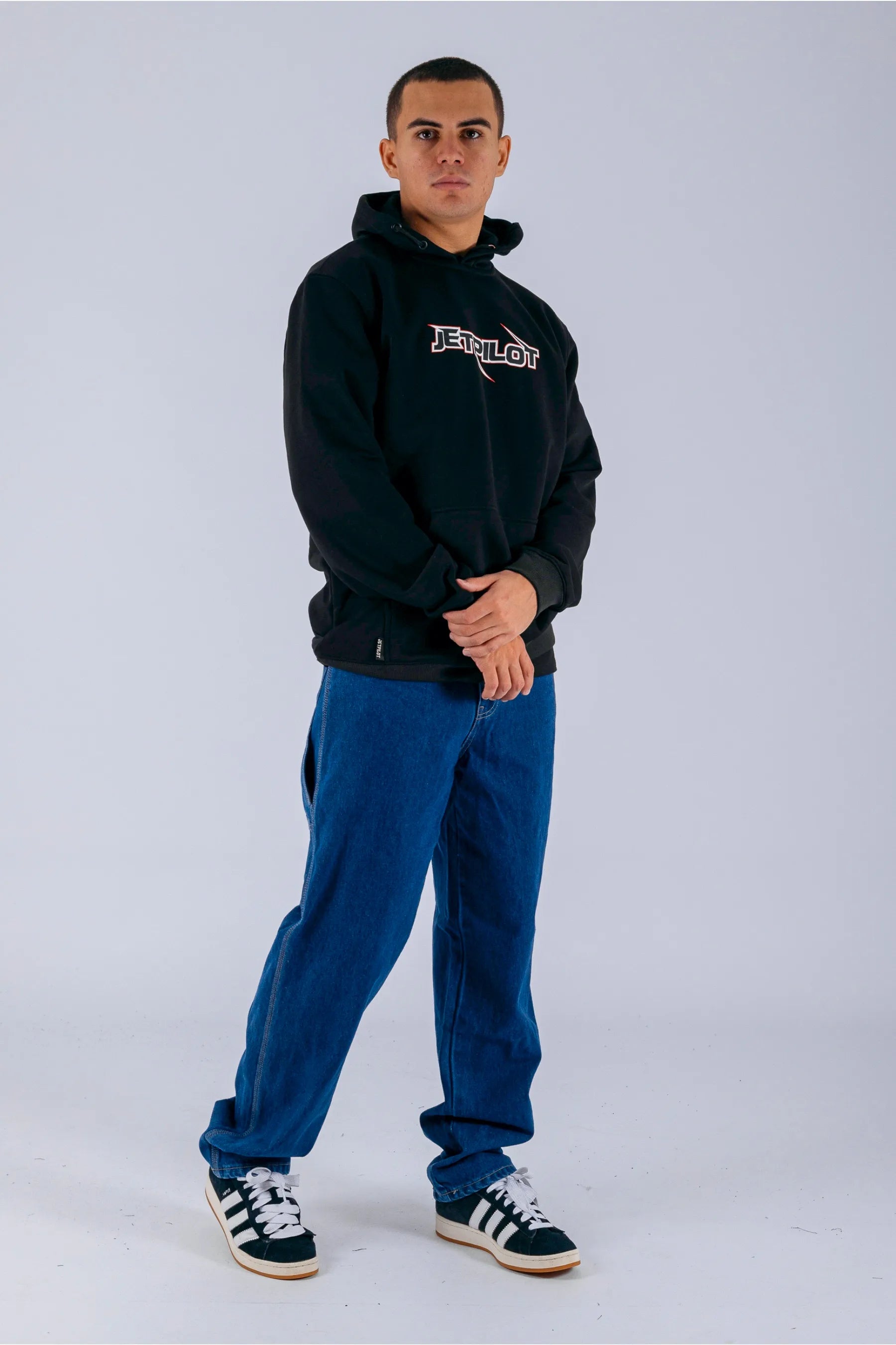 a person wearing a black pullover with a Jetpilot logo, blue shorts and a black/white shoes — view 5 (11)
