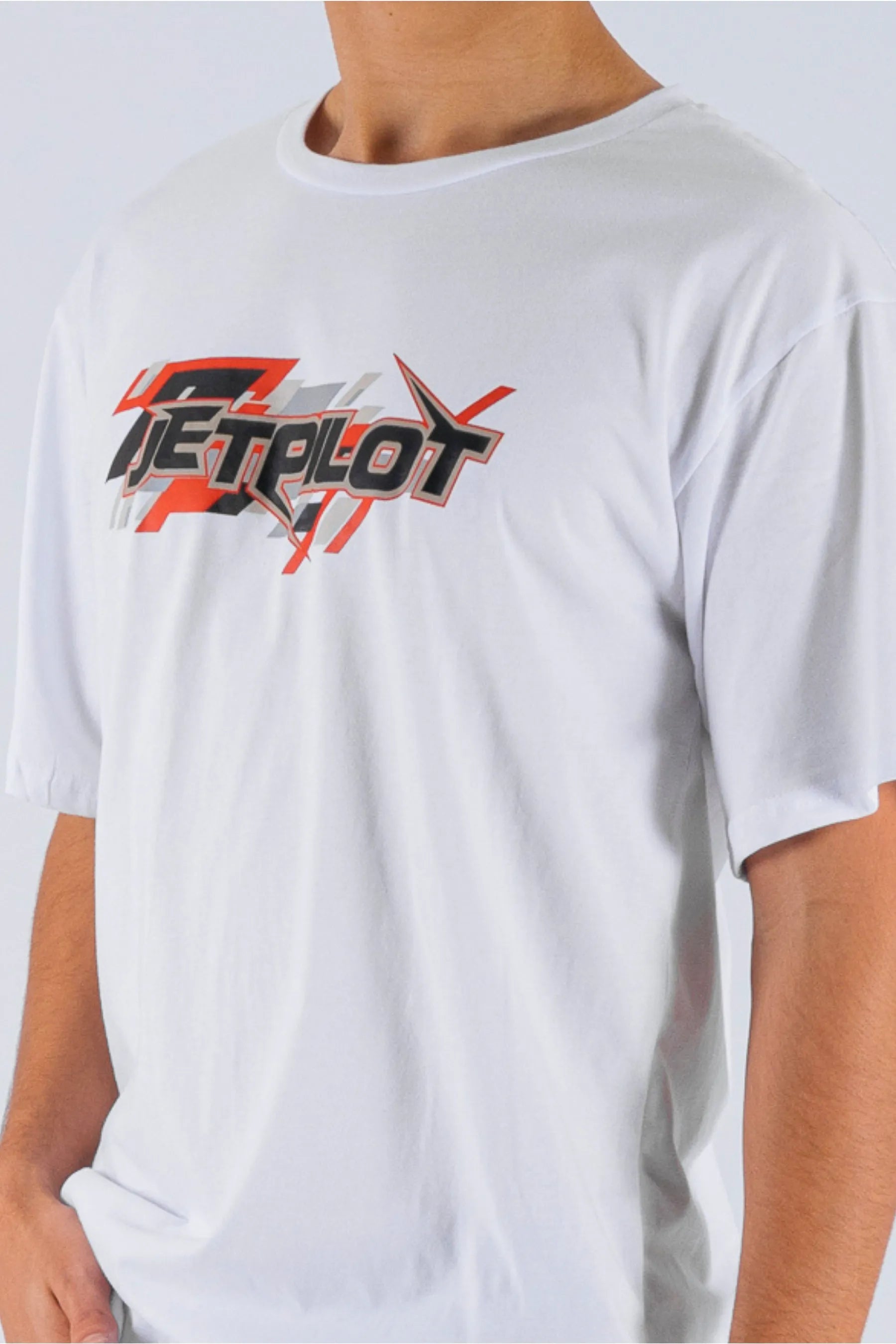 Close up of a person wearing a white tee with a Jetpilot logo on a white background — view 5 (3)