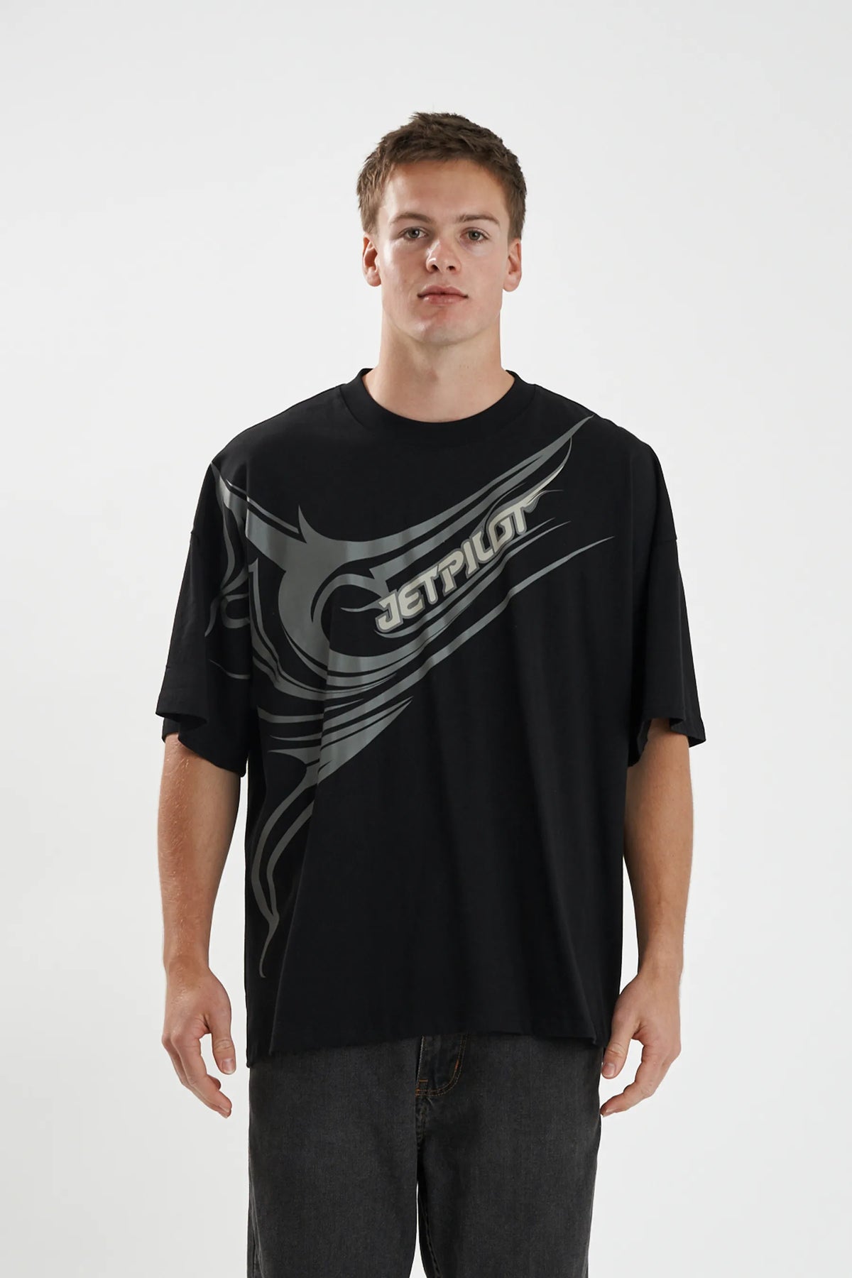 Model wearing the black Jetpilot Sinister Tee with its tonal grey wrap print, front view