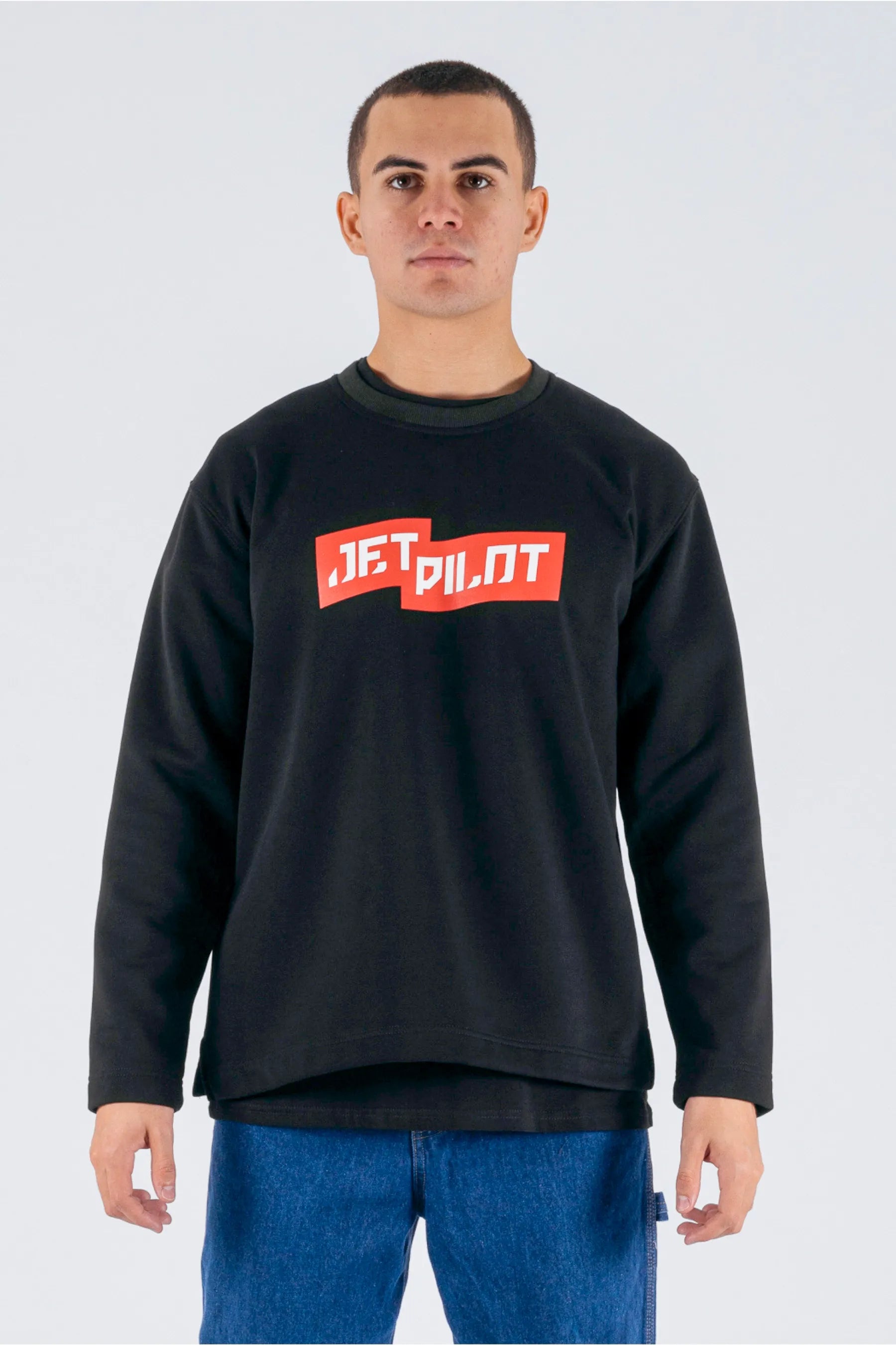 Front view of a person wearing a black crew with a red Jetpilot logo on a white background. — view 1 (3)