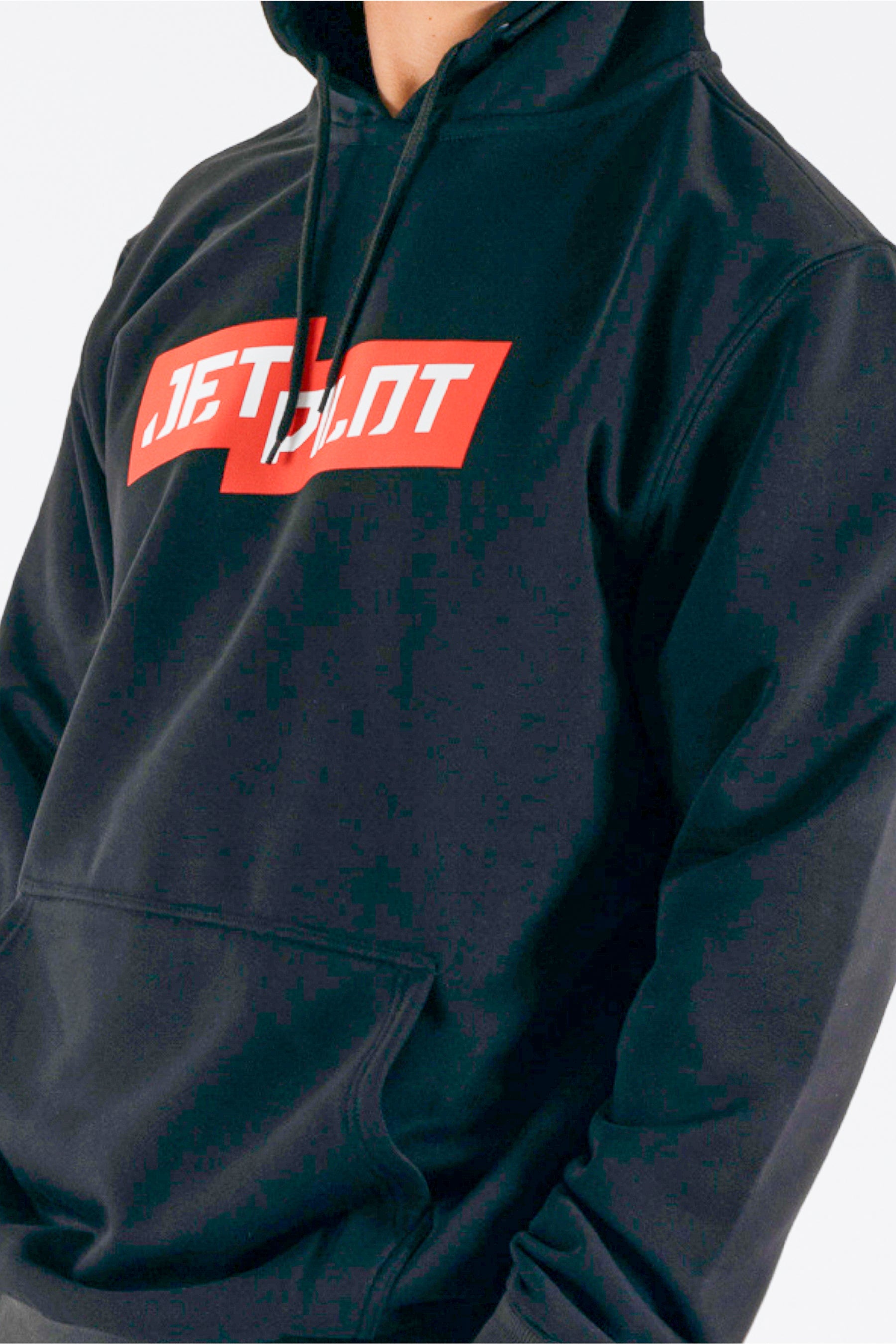 Close up of a person wearing a black pullover with a red Jetpilot logo — view 5 (3)