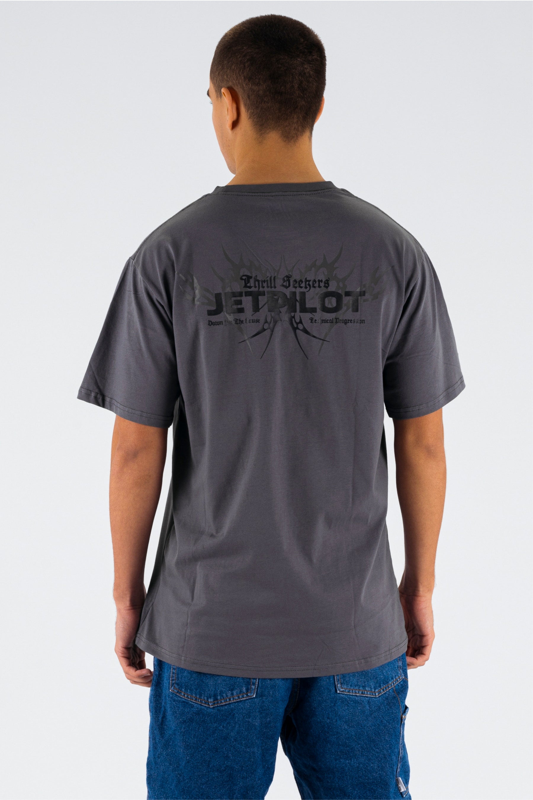 Back view of a person wearing a charcoal tee with a black Jetpilot logo on a white background — view 2 (3)