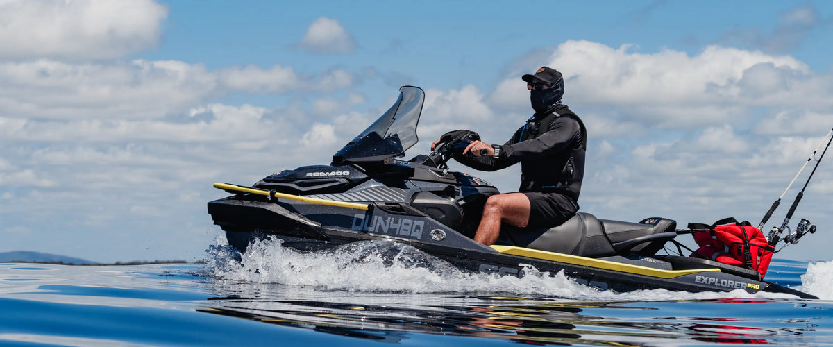 Rider in a Jetpilot Venture life jacket in Black, running a jet ski with fishing rods on board